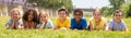 Group of school children resting on grass and smiling