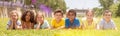 Group of school children resting on grass and smiling Royalty Free Stock Photo