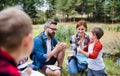 Group of school children with teacher on field trip in nature, learning science. Royalty Free Stock Photo