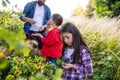 Group of school children with teacher on field trip in nature, learning science. Royalty Free Stock Photo