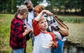 Group of school children with teacher on field trip in nature, learning science. Royalty Free Stock Photo