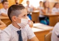 Group of school kids with pens and notebooks writing test in classroom Royalty Free Stock Photo