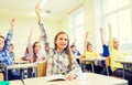 Group of school kids raising hands in classroom Royalty Free Stock Photo