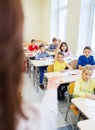 Group of school kids raising hands in classroom Royalty Free Stock Photo