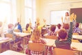 Group of school kids raising hands in classroom Royalty Free Stock Photo