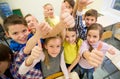 Group of school kids showing thumbs up