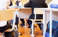 Group of school kids sitting and listening to teacher in classr