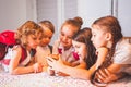 Group of school kids with smartphone having fun on break in classroom Royalty Free Stock Photo