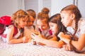 Group of school kids with smartphone having fun on break in classroom Royalty Free Stock Photo