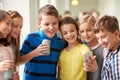 Group of school kids with smartphone and soda cans Royalty Free Stock Photo