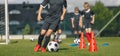 Group of School Kids at Soccer Training. Boys Kicking Classic Black and White Soccer Balls in Slalom Training Drill Royalty Free Stock Photo