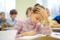 Group of school kids writing test in classroom