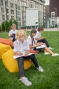 Group of schoolchildren having a lesson outside and looking concentrated