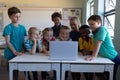 Group of schoolchildren using a laptop computer in an elementary school classroom