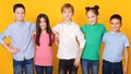 Group of schoolkids standing in row, looking at camera