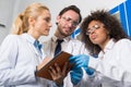 Group Of Scientific Workers Taking Notes Making Research In Laboratory, Mix Race Team Of Scientists Writing Results Of