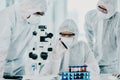 Group of scientists conducting medical research in hazmat suits and protective gloves, for coronavirus cure in a Royalty Free Stock Photo