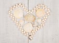 group of sea shells and pearls laid out in the shape of heart on white wooden background Royalty Free Stock Photo