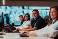 Group of Security data center operators working in a CCTV monitoring room looking on multiple monitors Officers