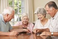 Group Of Senior Couples Enjoying Game Of Dominoes At Home Royalty Free Stock Photo