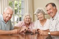 Group Of Senior Couples Enjoying Game Of Dominoes At Home Royalty Free Stock Photo