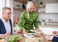 Group of senior friends at dinner party at home, eating. Royalty Free Stock Photo