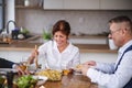 Group of senior friends at dinner party at home, eating. Royalty Free Stock Photo