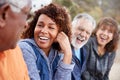 Group Of Senior Friends On Hike In Countryside Talking And Laughing Together