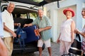 Group Of Senior Friends Loading Luggage Into Trunk Of Car About To Leave For Vacation Royalty Free Stock Photo