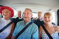 Group Of Senior Friends Sitting In Back Of Van Being Driven To Vacation Royalty Free Stock Photo