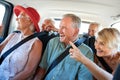 Group Of Senior Friends Sitting In Back Of Van Being Driven To Vacation Royalty Free Stock Photo