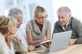 Group of senior friends using tablet and laptop Royalty Free Stock Photo