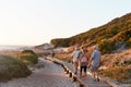 Group Of Senior Friends Walking Along Boardwalk At Beach On Summer Group Vacation Royalty Free Stock Photo