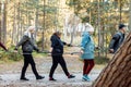 Group senior people, campers make Nordic walking one by one in column, hold trekking poles in forest. Exercise hiking Royalty Free Stock Photo