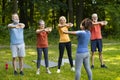 Group of senior people having fitness class outdoors, training with female instructor Royalty Free Stock Photo