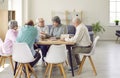 Group of senior people men and women talking in nursing home sitting at the table. Royalty Free Stock Photo