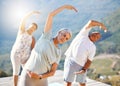 Group of senior people stretching with their hands over heads outdoors. Mature people doing yoga exercise in nature on a Royalty Free Stock Photo