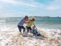 Group of three senior women laughing as falling down in the water on beach. Humor senior health Royalty Free Stock Photo