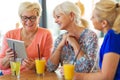 Group of senior women using tablet in a bar Royalty Free Stock Photo