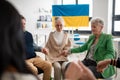 Group of seniors holding hands and praying for Ukraine together in church community center. Royalty Free Stock Photo