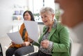 Group of seniors with papers singing together at choir rehearsal. Royalty Free Stock Photo