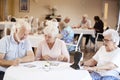 Group Of Seniors Playing Game Of Bingo In Retirement Home