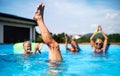 Group of seniors in swimming pool outdoors in backyard, having fun. Royalty Free Stock Photo