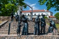 A group of seven bronze sculptures AFTER WORSHIP on the steps at the church, Saldus, Latvia