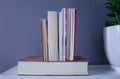 Group of several reading books, one of them lying down and the other books standing on the biggest book, all of them on a grey Royalty Free Stock Photo