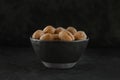 a group of shell walnuts in a black texture bowl on a black background Royalty Free Stock Photo