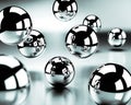 Floating chrome spheres with detailed reflections of smaller spheres and light against a blurred, metallic surface Keywords: Royalty Free Stock Photo