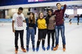 Group shot of teenage friends on the rink ice skating rink