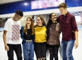 Group shot of teenage friends on the rink ice skating rink