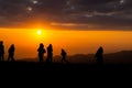 Group of silhouette people on top of a mountain on sunset